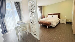 Een hotelkamer met een bed, nachtkastjes, een bureau en een stoel.