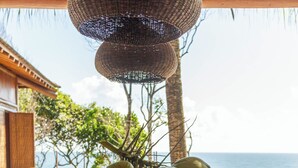 A dining table set with various dishes, a bottle of milk, and a view of the ocean. - Villa Toucan (Itacaré)