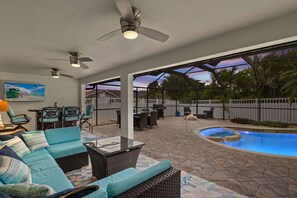 Un patio techado con piscina, mobiliario exterior y vistas del paisaje circundante.