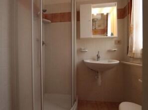 Ein Badezimmer mit Dusche, Waschbecken und Toilette.