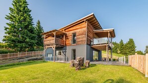 A modern two-story house with a wooden exterior, large windows, and a balcony. - Beautiful apartment for 6 people with WIFI, TV, terrace and pets allowed (Frauenstein)