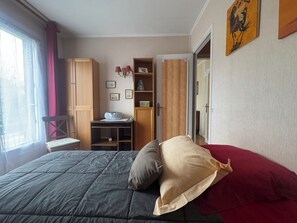 Ein Schlafzimmer mit Bett, Schreibtisch, Stuhl und Kleiderschrank.