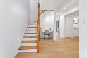 A staircase with wooden balusters leading to a dining area with a table and chairs.