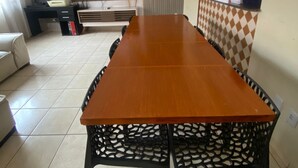 A dining area with a long wooden table and black chairs with intricate designs. - Cozy 3/4 House - Air conditioning in 3/4. Garage. (Palmas)