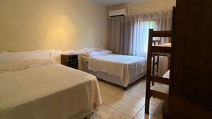 A room with two single beds, a desk, a chair, and an air conditioning unit. - Cozy 3/4 House - Air conditioning in 3/4. Garage. (Palmas)