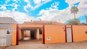 A building with a covered walkway, a satellite dish, and a palm tree in the background. - Cozy 3/4 House - Air conditioning in 3/4. Garage. (Palmas)