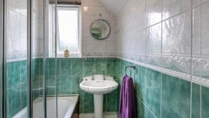 Ein Badezimmer mit Badewanne, Waschbecken und Fenster.