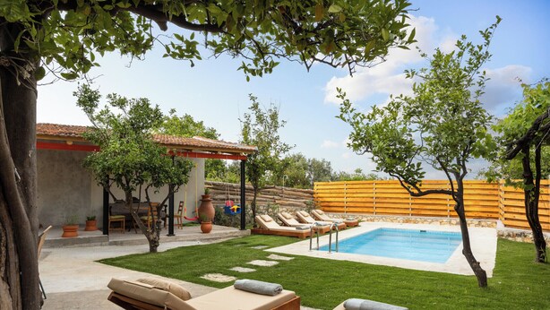 A backyard with a swimming pool, lounge chairs, and a pergola. - The Olive Mill House Luxe Villa (Rethymno)