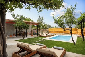 A backyard with a swimming pool, lounge chairs, and a pergola. - The Olive Mill House Luxe Villa (Rethymno)