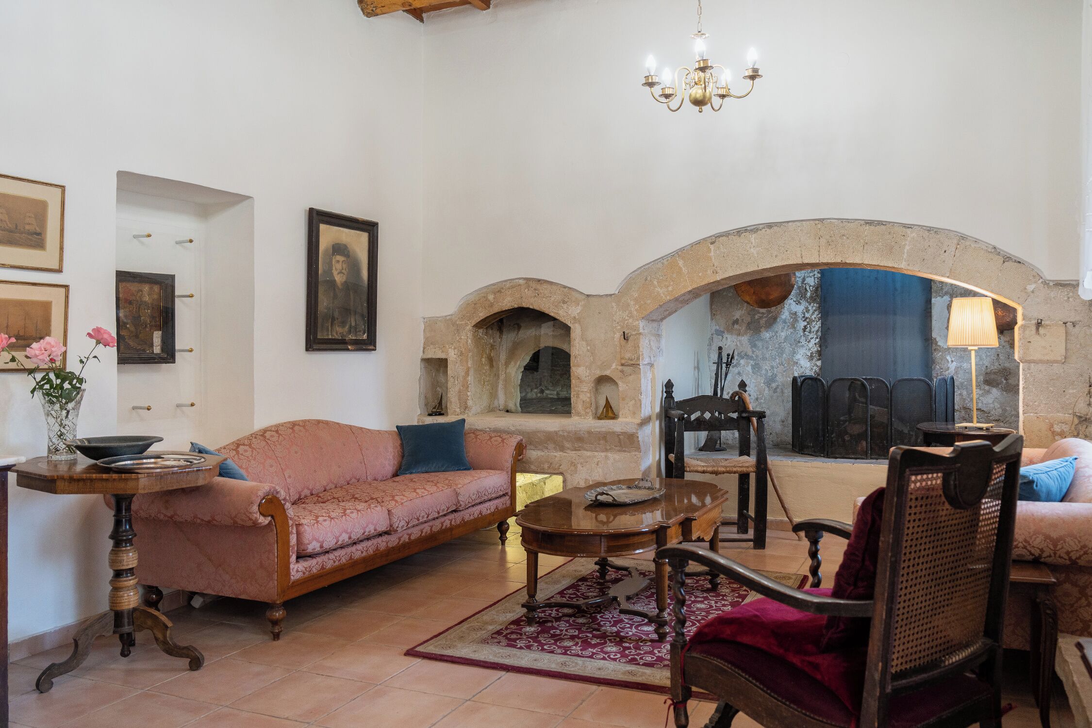 A living room with a sofa, armchairs, a coffee table, and a fireplace.