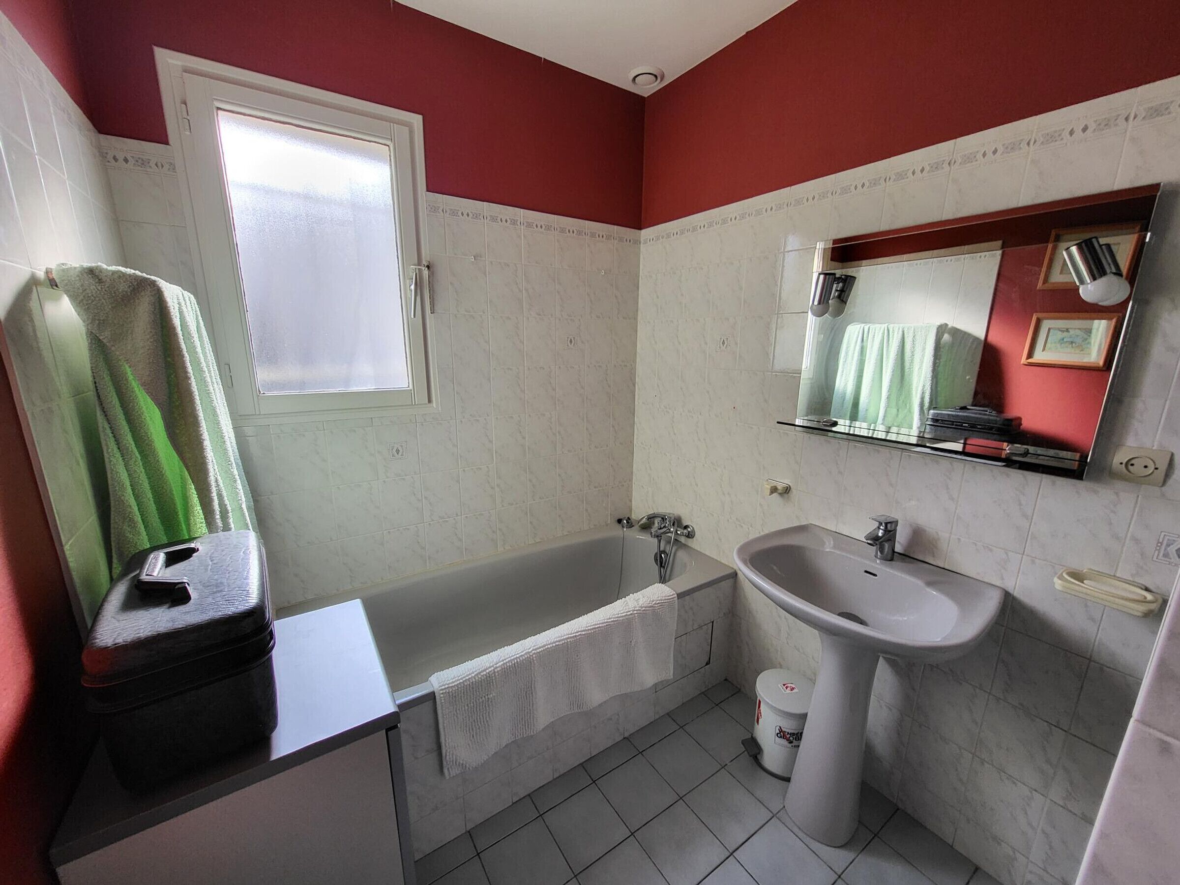 A bathroom with a bathtub, a sink, and a window.