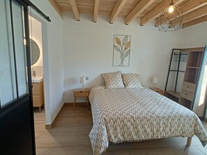 A bedroom with a bed, bedside tables, a wardrobe, and a wall art piece.