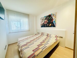 Une chambre à coucher avec un lit, une fenêtre et un tableau accroché au mur.