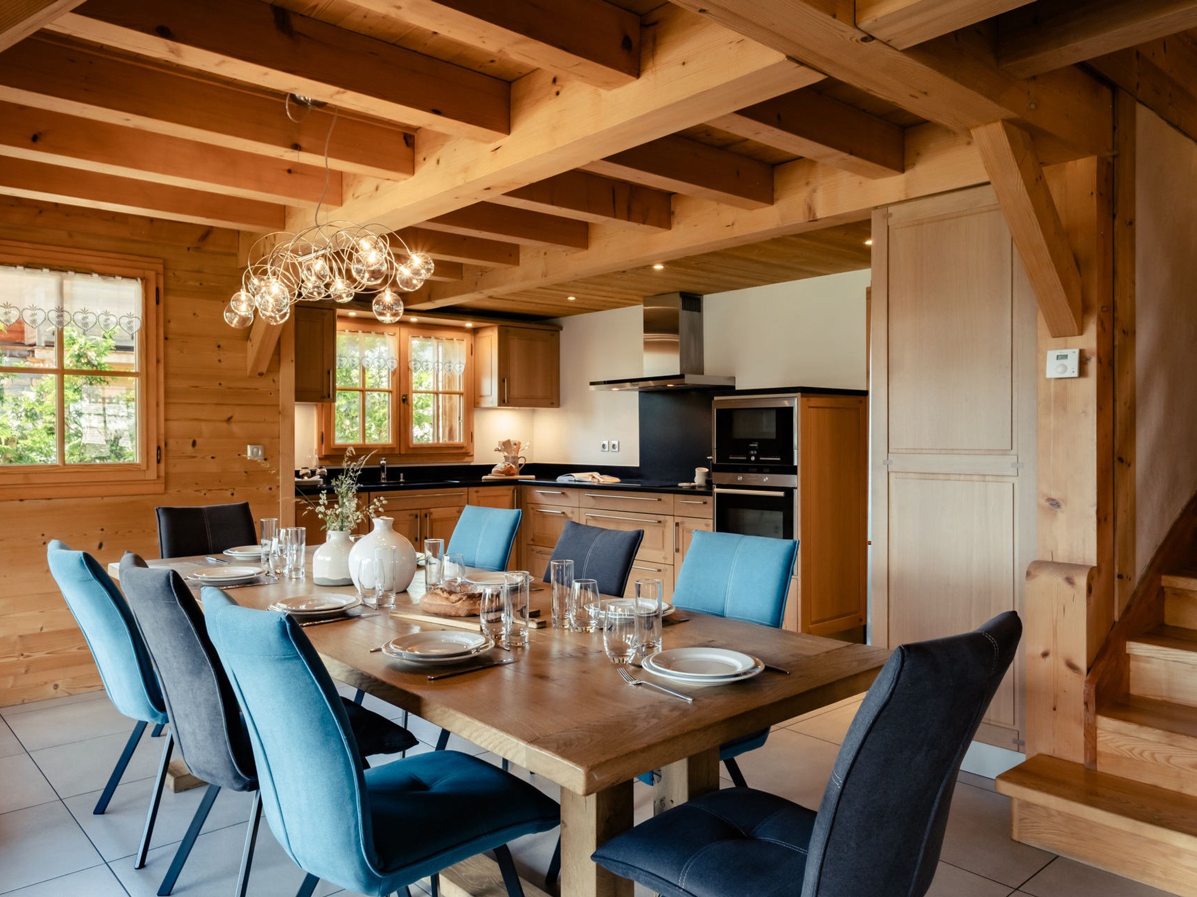A wooden interior with a dining area, kitchen, and staircase.