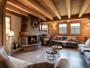 A cozy log cabin interior with a stone fireplace, wooden beams, and a comfortable seating area. - 4★ Chalet, 5 beds, outdoor spa, near shuttle, pets welcome (La Clusaz)