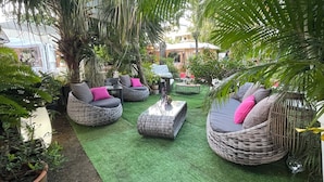 A cozy outdoor seating area with wicker furniture and artificial grass.