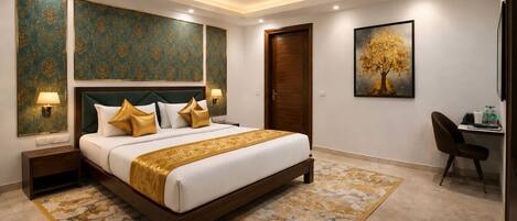 A hotel room with a large bed, a desk, a chair, a ceiling fan, and a painting on the wall.