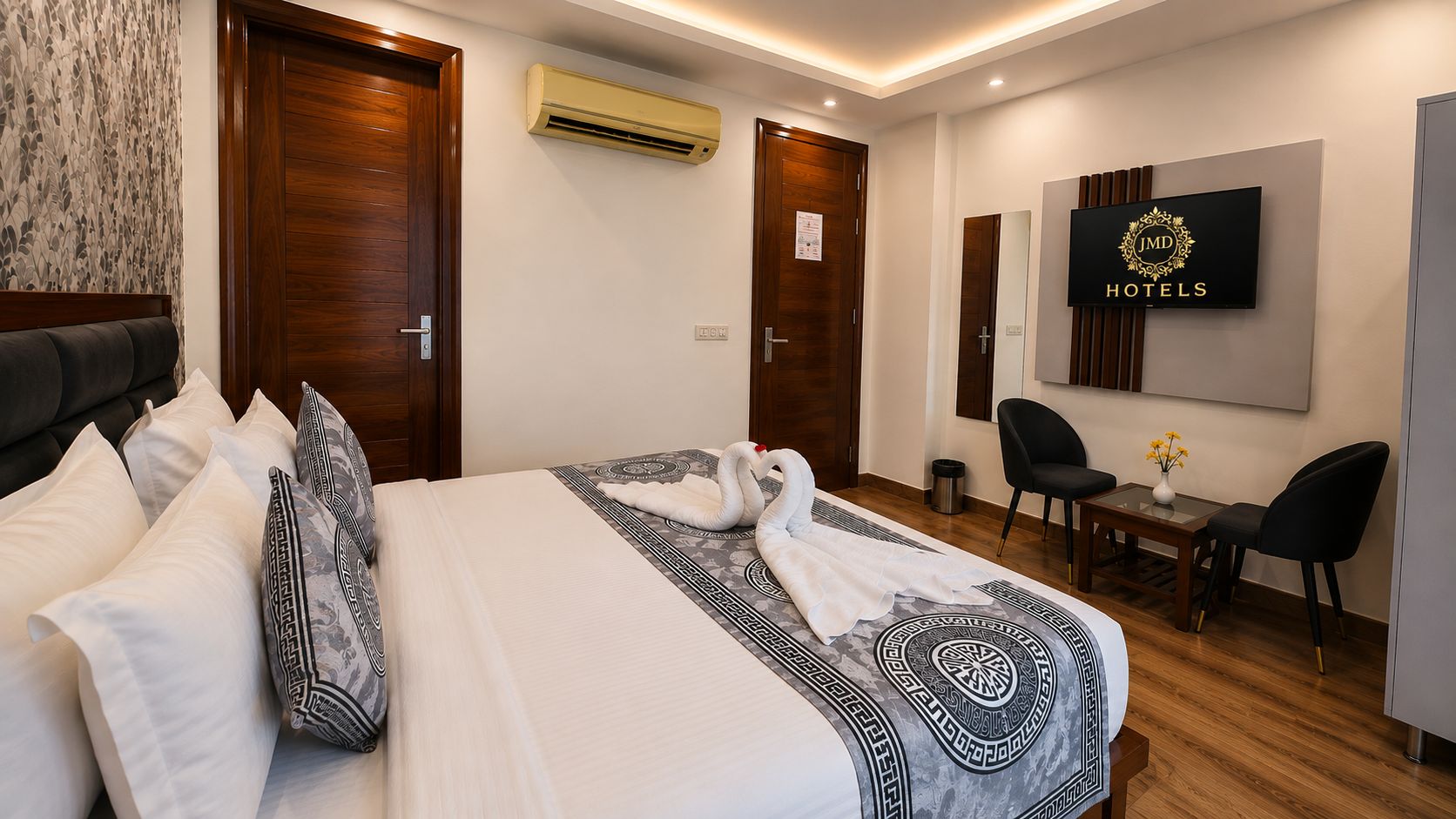 A hotel room with a bed, a desk, a chair, and a television.