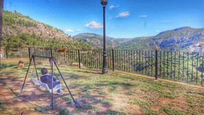 A swing set in a park with a view of a mountainous landscape. - Cau de l'Art (Llucena)