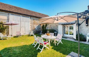 A patio with outdoor furniture, a stone wall, and a covered area with a table and chairs. - Cozy home in Gageac-et-Rouillac (Gageac-et-Rouillac)