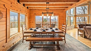 A wooden cabin with a dining area featuring a large table, chairs, and hanging pendant lights. - 5BR w/MTN Views*Firepit*Hot Tub*Theater*Games (Sevierville)