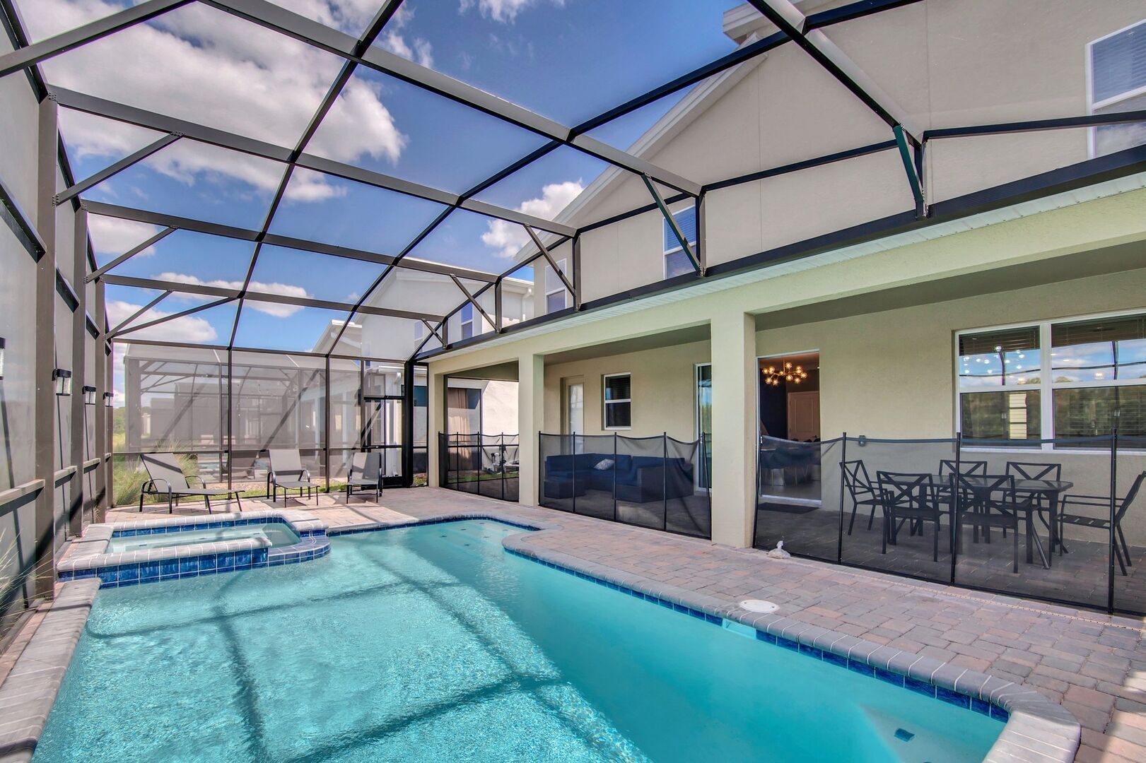 A covered outdoor swimming pool with lounge chairs and a patio area.