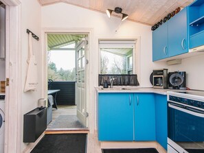 A compact kitchen with blue cabinets, a coffee maker, and a microwave. - 4 Star Holiday Home in Hovborg (Hovborg)
