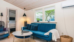 A cozy living room with a blue sofa, a round coffee table, and a woven rug. - 4 Star Holiday Home in Hovborg (Hovborg)