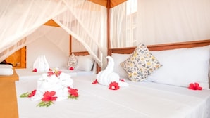 Un lit bien fait, avec des draps blancs, un coussin à motifs floraux et un coussin en forme de cygne.