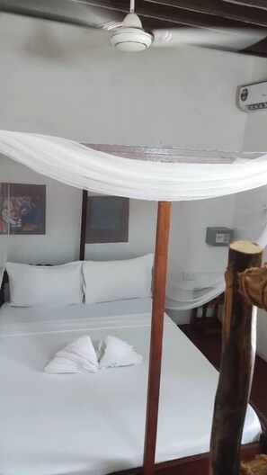 Una habitación con cama con dosel, cabecera de madera y aire acondicionado de pared.