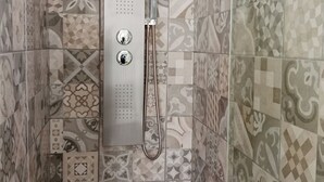 Et bruseområde med et moderne brusehoved og to betjeningsknapper.