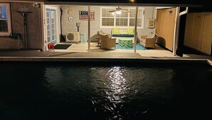Ein Haus mit Swimmingpool, überdachter Terrasse und Gartenmöbeln sowie einer Garage.