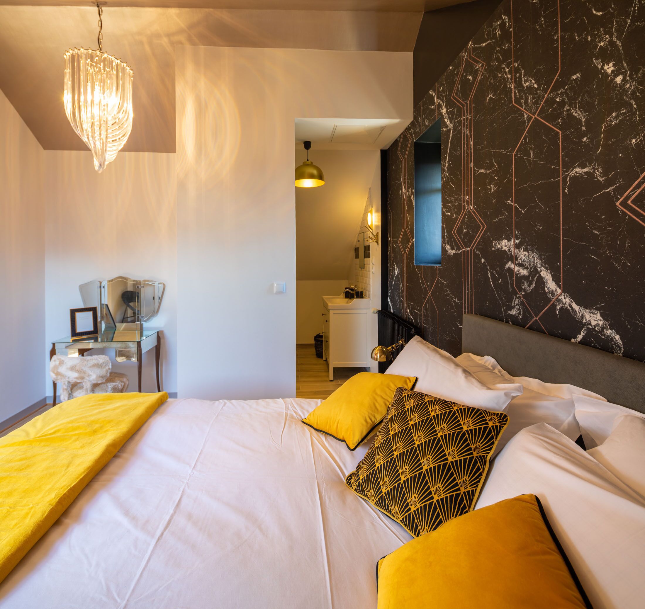 Una habitación de hotel moderna con una cama grande, un escritorio y una silla.
