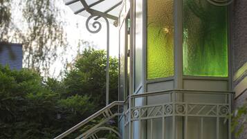 A staircase with ornate metal railings and a glass door with green-tinted glass.