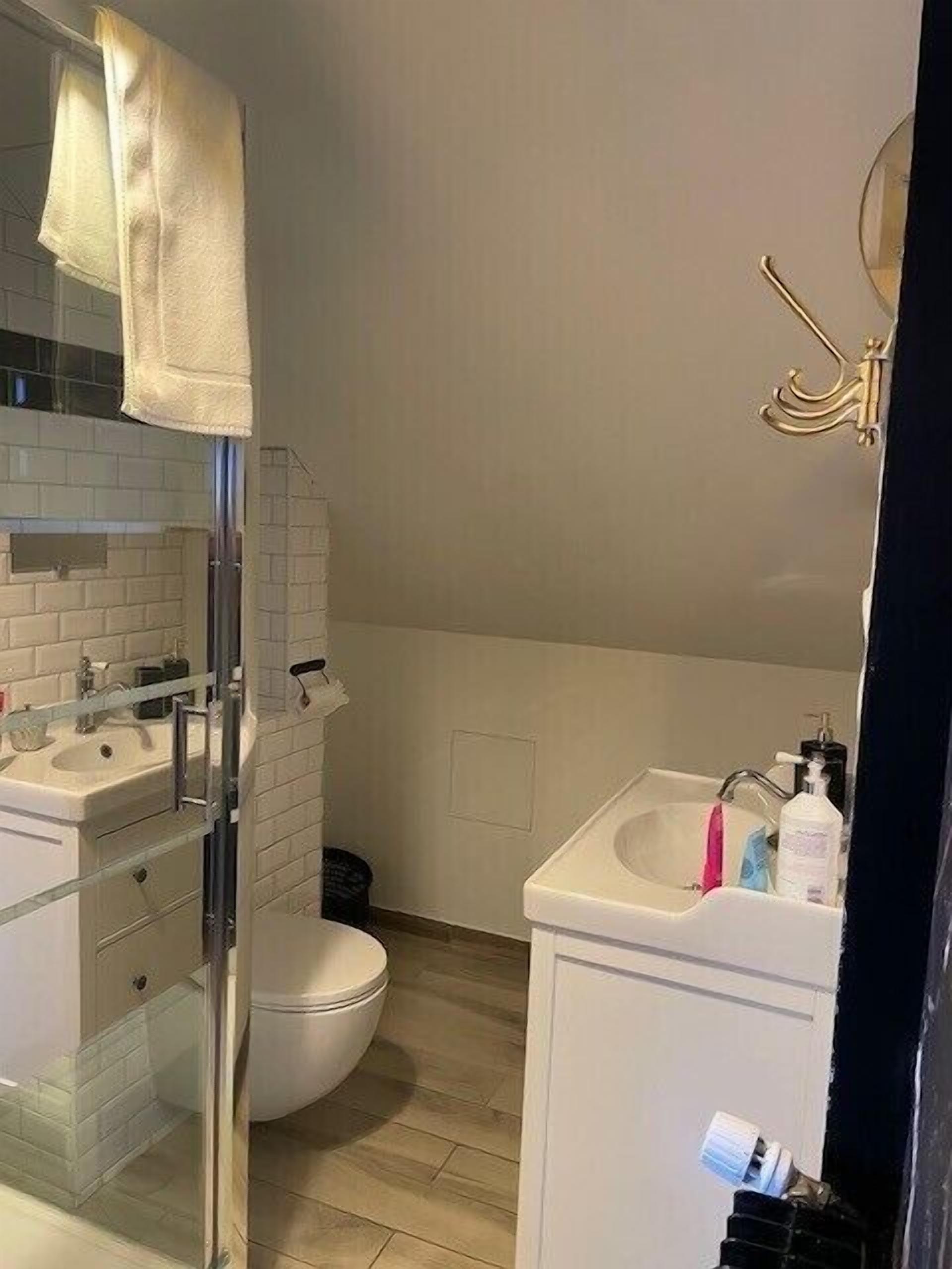 Une salle de bain avec une douche à parois de verre, des toilettes, un lavabo et un miroir.