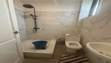 Een douche, handdoeken, zeep, toiletpapier