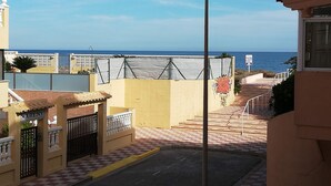 A coastal residential area with a view of the sea, a checkered pavement, and a fence with a gate labeled "MARENY". - Oasis  1º Solo Familias! (Xeraco Playa)