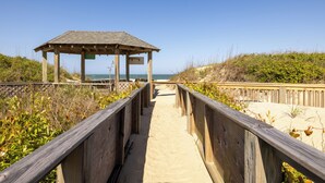 A wooden boardwalk leading to a beach with a wooden structure at the end. - Direct Oceanfront Access*Hot Tub*Neighborhood Pool (Nags Head)