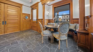 Un coin repas avec une table ronde, des chaises à motifs et un lambris en bois.