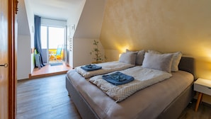 Une chambre avec un grand lit, une table de chevet et une vue sur l’extérieur.