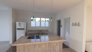 Una cucina moderna con isola centrale, piano cottura integrato e frigorifero.