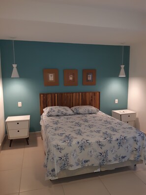 Cozy retreat with a floral-patterned bedspread, wooden headboard, and two bedside tables, each with a lamp.