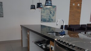 Una cucina moderna con isola centrale, elettrodomestici in acciaio inossidabile e illuminazione a sospensione.