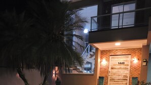 Un edificio moderno con un numero civico, una scala e un ingresso ben illuminato.