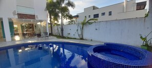 Relax by the pool, surrounded by lush greenery and a modern design.