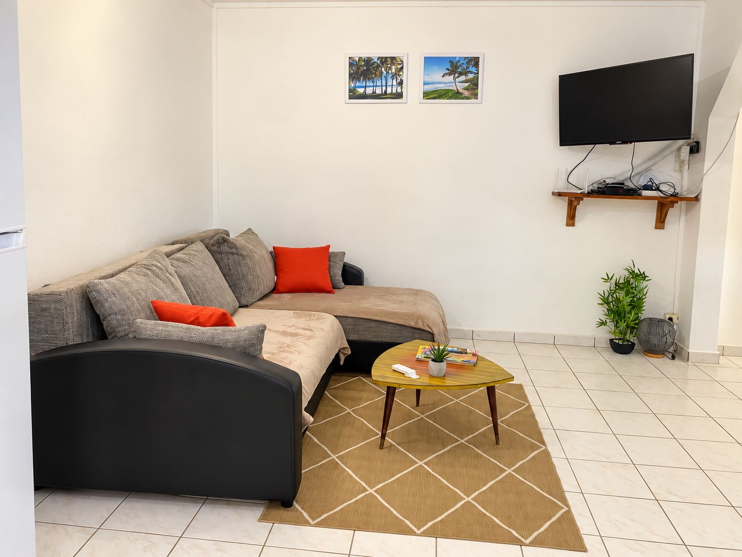 A modern living room with a sofa, coffee table, and a flat-screen TV mounted on the wall.