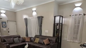 A living room with a brown leather sofa, a glass coffee table, and a decorative vase. - lg signature stays (Bangalore)
