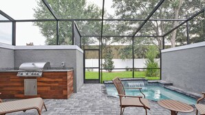 Eine Terrasse im Freien mit Grill, Sitzgelegenheit und kleinem Pool.