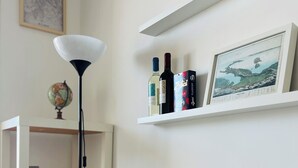 Une table blanche ornée d’une plante à fleurs blanches en pot, d’un globe terrestre et d’une lampe posée sur une étagère.