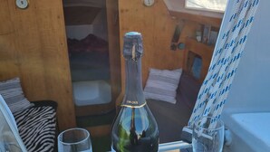 Una botella de champán y dos copas sobre una mesa dentro de un barco.